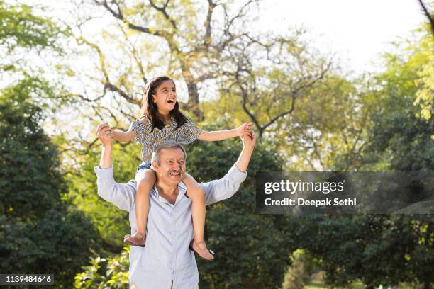 grandfather and granddaughter playful in garden - girl with brown hair stock pictures, royalty-free photos & images