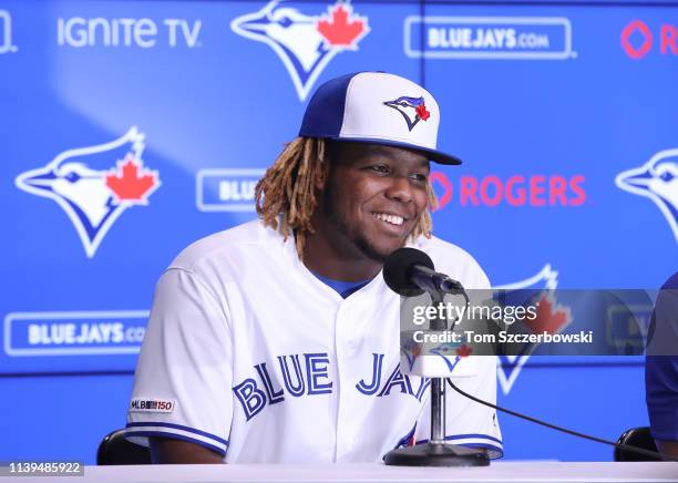 Vladimir Guerrero Jr. #27 of the Toronto Blue Jays smiles as he speaks to the media through an interpreter as he is introduced before his MLB debut...