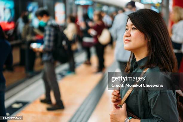 young woman traveler waiting train in subway mtr train station at hong kong city, china - subway station ストックフォトと画像