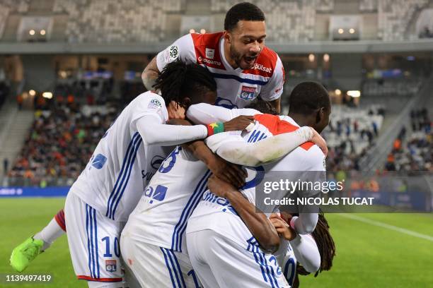 Lyon's players celebrate after scoring a goal during the French L1 football match between Bordeaux and Lyon on April 26, 2019 at the Matmut...