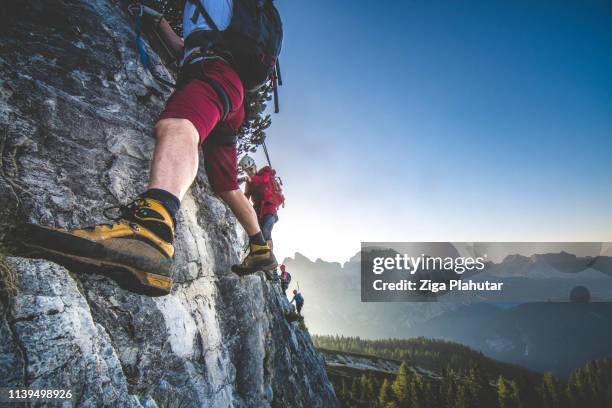 climbing on the mountaing edge - mountain climber exercise stock pictures, royalty-free photos & images
