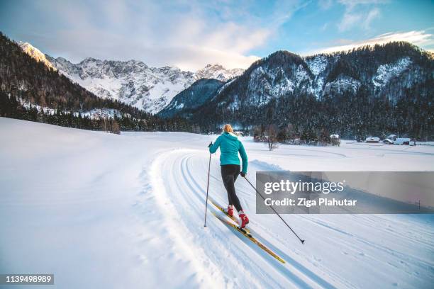 cross-country skiier gliding on the slopes - cross country stock pictures, royalty-free photos & images