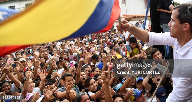 Venezuelan opposition leader and self-proclaimed acting president Juan Guaido flutters a Venezuelan national flag during a rally, as part of the...