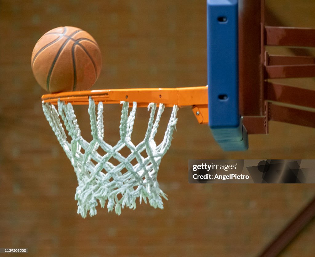 Basketball ball before enter inside the net