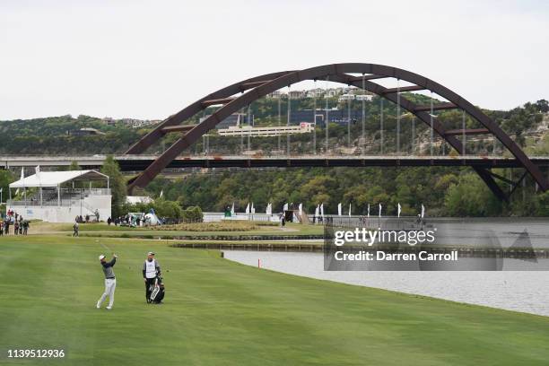 Lucas Bjerregaard of Denmark plays a shot on the 13th hole as caddie Jonathan Smart looks on during the semifinal round of the World Golf...