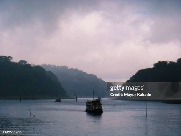 boating in periyar lake while black clouds in the sky - kerala rain fotografías e imágenes de stock