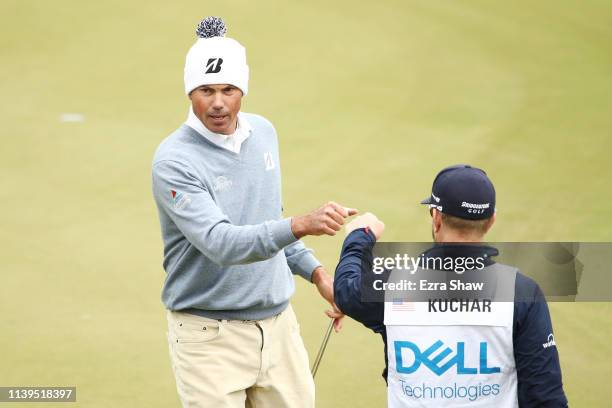 Matt Kuchar of the United States bumps fists with caddie John Wood on the 17th green in his match against Lucas Bjerregaard of Denmark during the...