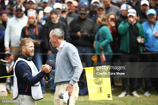 Matt Kuchar of the United States celebrates with his caddie John Wood after defeating Lucas Bjerregaard of Denmark 1up during the semifinal round of...