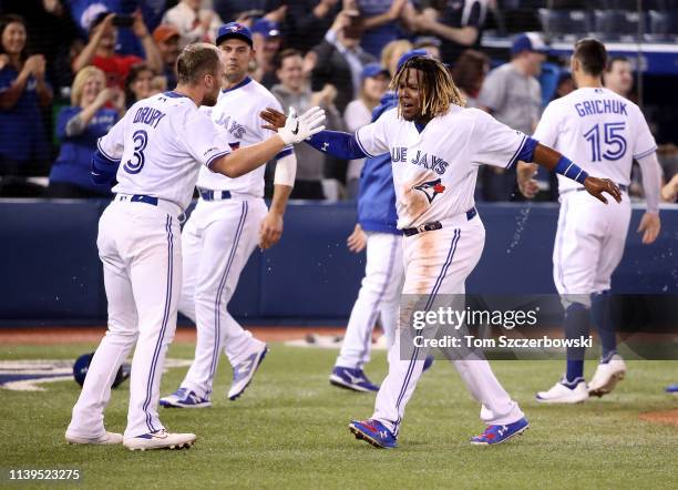 Vladimir Guerrero Jr. #27 of the Toronto Blue Jays celebrates their victory as Brandon Drury hit a game-winning two-run home run in the ninth inning...