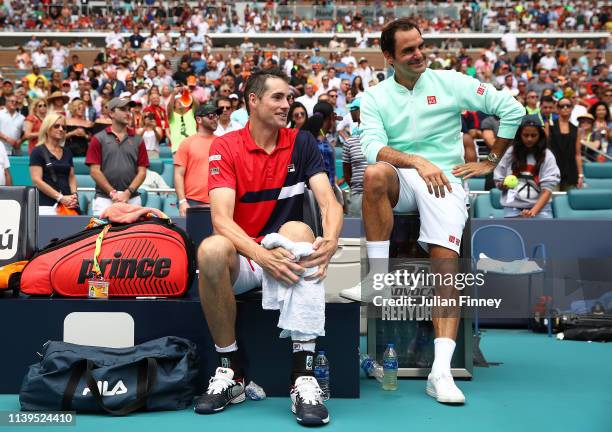 Winner Roger Federer of Switzerland sits with runner up John Isner of USA after the final during day fourteen of the Miami Open tennis on March 31,...