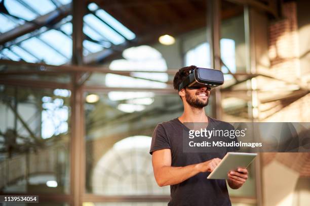 der mensch mit dem headset des virtual-reality-simulators - virtual reality stock-fotos und bilder