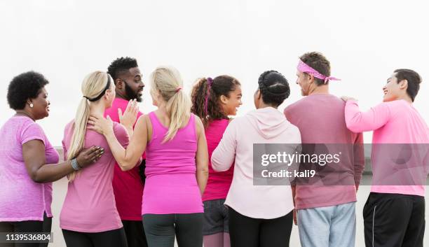 groupe d’hommes et de femmes en rose, au rassemblement de cancer du sein - femme dans un groupe dhommes photos et images de collection
