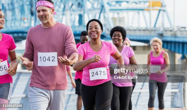 donna afroamericana con gruppo in rally cancro al seno - gara di marcia veloce foto e immagini stock