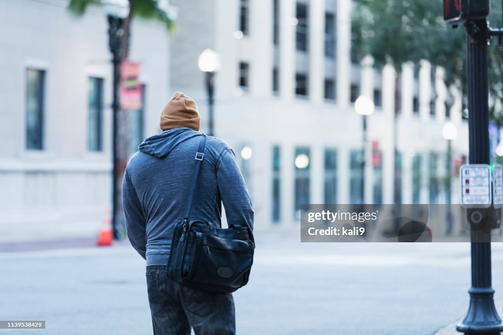 Achteraanzicht van volwassen Hispanic man wandelen in de stad