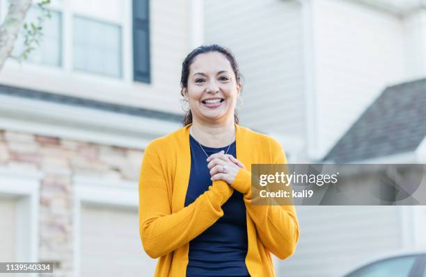 mature hispanic woman standing outside home - person in front of house stock pictures, royalty-free photos & images