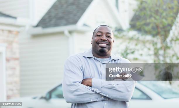 mature african-american man standing outside home - standing on top of car stock pictures, royalty-free photos & images