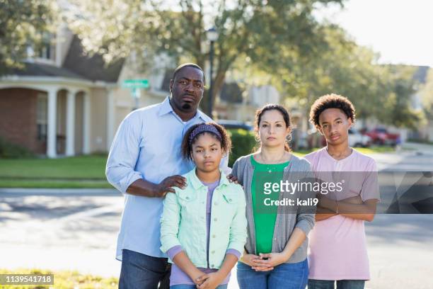 serious interracial family in residential community - family serious stock pictures, royalty-free photos & images