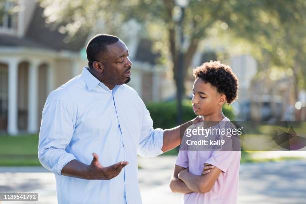 father disciplining or giving advice to teenage boy - serious teenager boy stock pictures, royalty-free photos & images