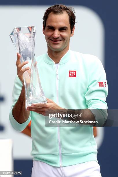 Roger Federer of Switzerland celebrates with the Butch Buchholz Trophy after defeating John Isner during the men's final of the Miami Open Presented...