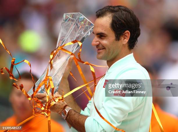 Roger Federer of Switzerland celebrates with the winners trophy against John Isner of USA in the final during day fourteen of the Miami Open tennis...