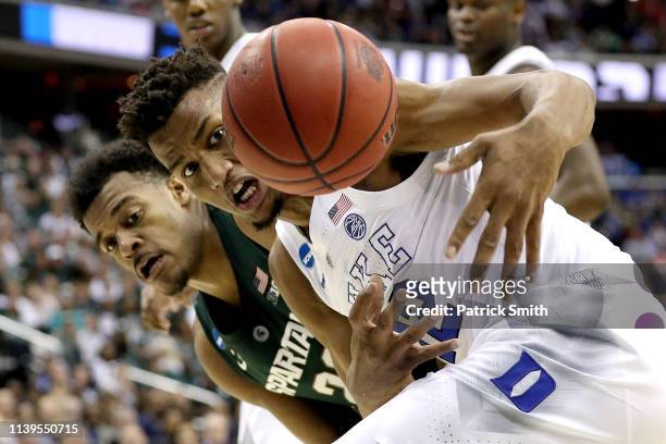 Xavier Tillman of the Michigan State Spartans and Javin DeLaurier of the Duke Blue Devils battle for the ball during the first half in the East...