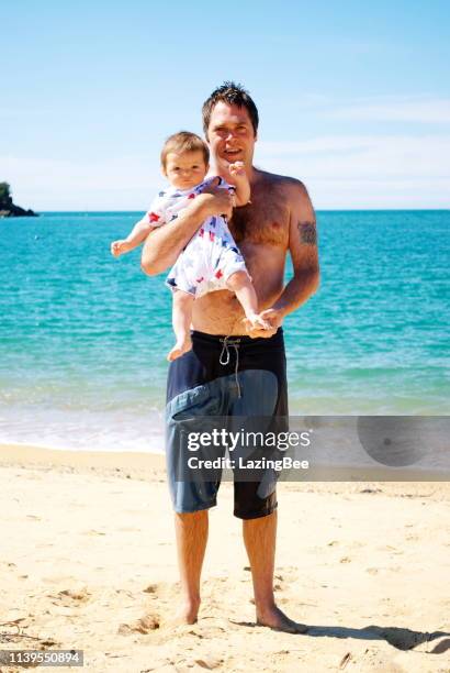 vader en baby op het strand in de zomer - kaiteriteri stockfoto's en -beelden