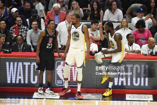 Lou Williams of the LA Clippers is seen with Kevin Durant, and Draymond Green of the Golden State Warriors during Game Six of Round One of the 2019...