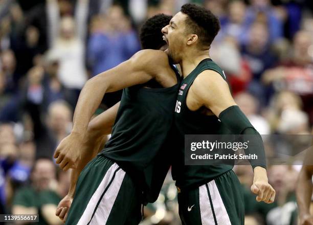 Xavier Tillman and Kenny Goins of the Michigan State Spartans celebrate the basket against the Duke Blue Devils during the second half in the East...