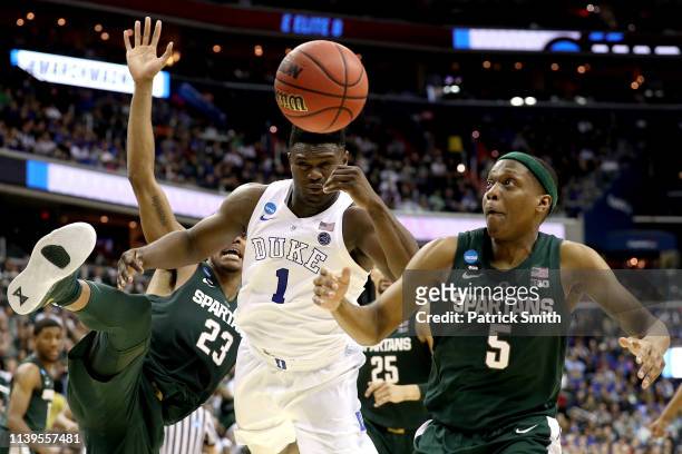 Zion Williamson of the Duke Blue Devils battles for the ball with Xavier Tillman and Cassius Winston of the Michigan State Spartans during the second...