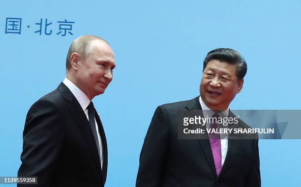 China's President Xi Jinping and Russia's President Vladimir Putin smile during the welcoming ceremony on the final day of the Belt and Road Forum in...