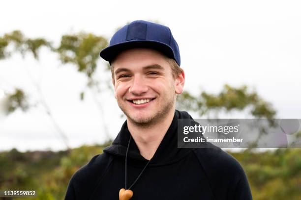 retrato de joven sonriente guapo con gorra, backgroun con espacio de copia - 18 19 años fotografías e imágenes de stock