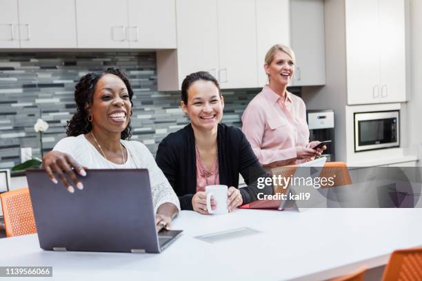 three multi-ethnic mature women in an office break room - only mature women stock pictures, royalty-free photos & images