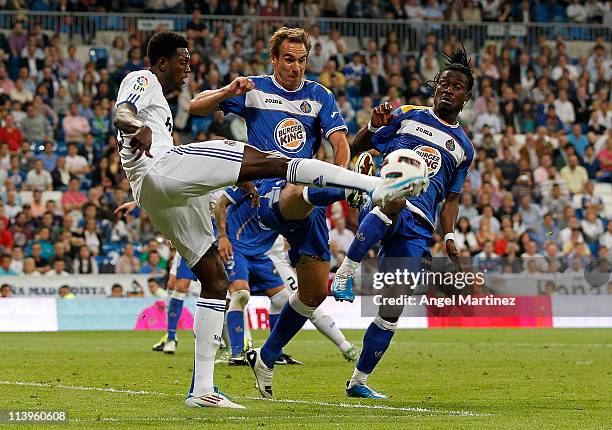 Emmanuel Adebayor of Real Madrid fights for the ball with Borja Fernandez and Derek Boateng of Getafe during the La Liga match between Real Madrid...