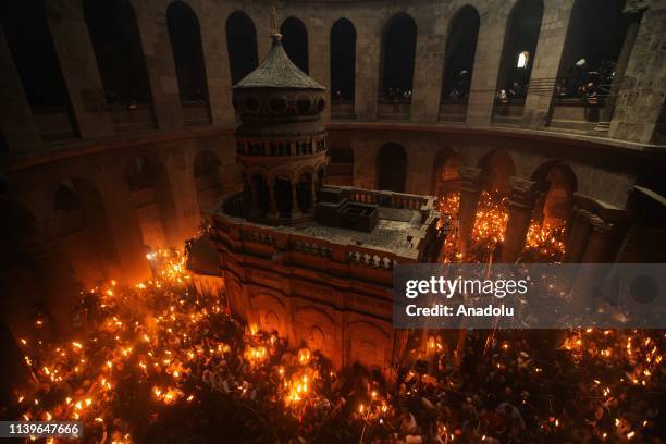 Orthodox Christian worshippers hold up candles lit from the Holy Fire as they gather at the Tomb of Christ as the miracle of the Holy Fire ceremony...