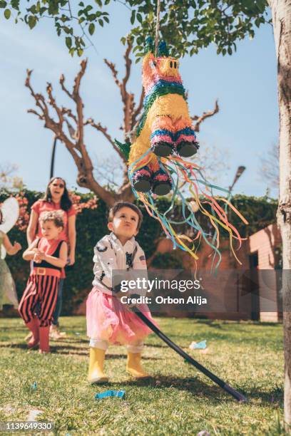 jungs brechen piñata auf einer party - piñata stock-fotos und bilder