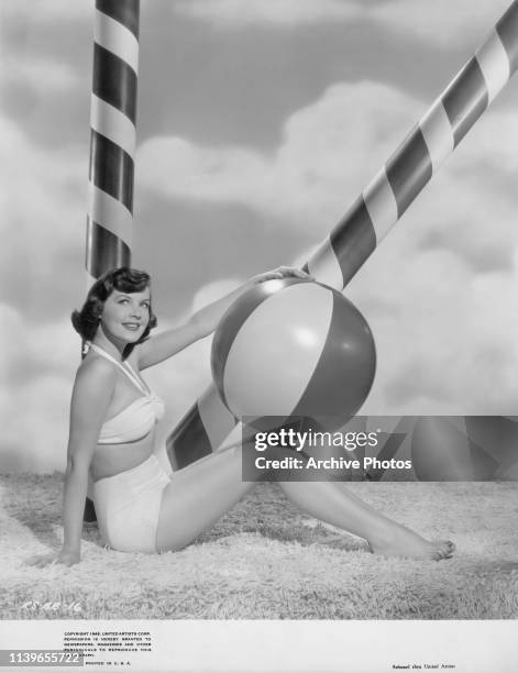 American actress and singer Barbara Bates with a beach ball, 1949.
