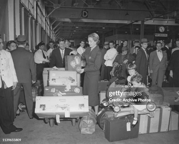 Scottish-born actress Deborah Kerr retrieves her own luggage upon her arrival in New York City on the 'Queen Mary', as the East Coast longshoremen or...