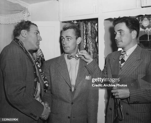 From left to right, actors William Bendix, Alan Ladd and Noah Beery Jr. Trying on ties, 24th January 1943.