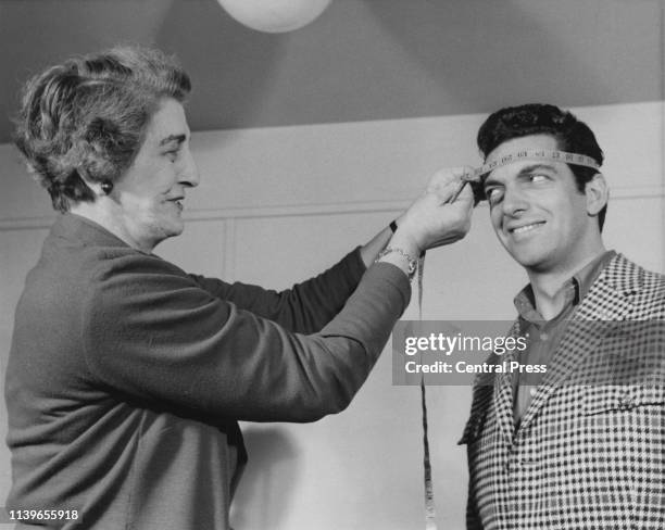 English singer Frankie Vaughan has his head measured for a waxwork at Madame Tussauds in London, December 1961.