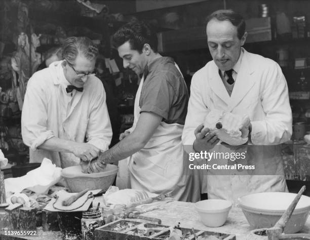 English singer Frankie Vaughan has his hands cast in plaster for a waxwork at Madame Tussauds in London, December 1961. The piece of wood in the cast...