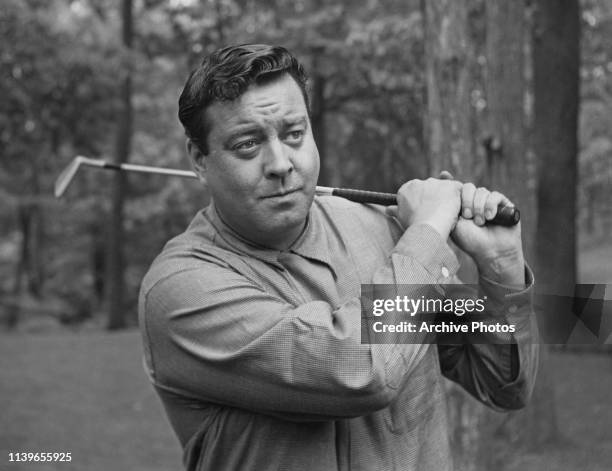American actor and comedian Jackie Gleason playing golf, circa 1955.