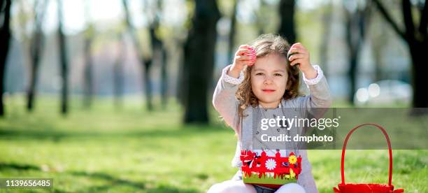 sorgfri liten flicka leker med korg full av påskägg - easter eggs basket bildbanksfoton och bilder