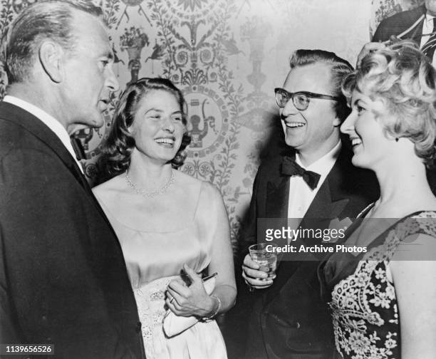 From left to right, actors Gary Cooper and Ingrid Bergman, her husband Lars Schmidt and her daughter Pia Lindstrom at a party in Hollywood,...