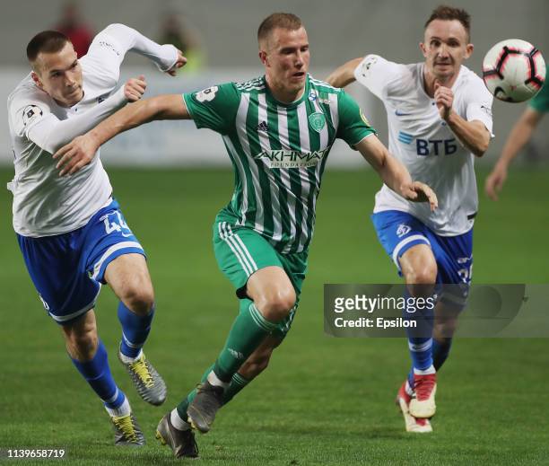 Tony Sunic and Aleksei Kozlov of FC Dinamo Moscow and Bekim Balaj of FC Akhmat Grozny vie for the ball during the Russian Premier League match...