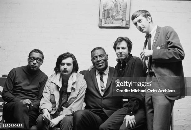 American electric blues band the Siegel-Schwall Band pose with American blues singer and musician Howlin' Wolf backstage at the Cafe Au Go Go in New...