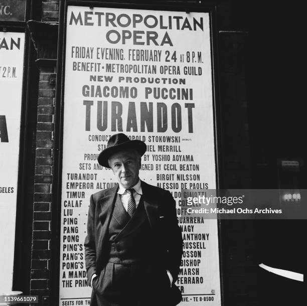 English fashion designer Cecil Beaton in front of a poster advertising the Puccini opera 'Turandot' at the Metropolitan Opera in New York City, 1961....
