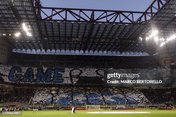 Inter Milan's supporters hold placards reading "Game over" dedicated to the elimination of Juventus from the Champions League during the Italian...
