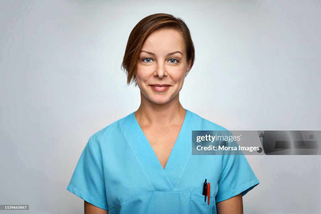 Female nurse smiling over white background