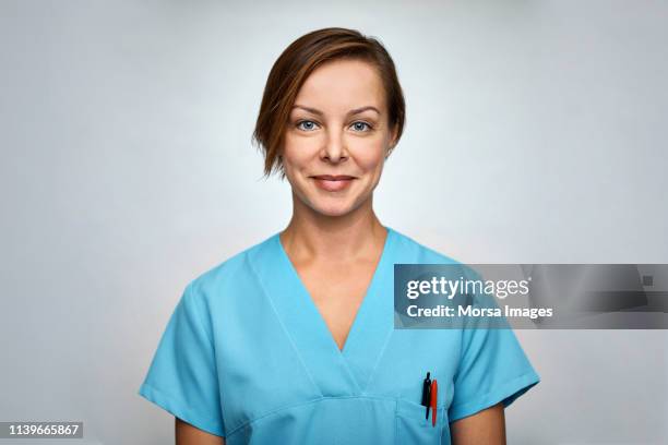 female nurse smiling over white background - medical scrubs bildbanksfoton och bilder