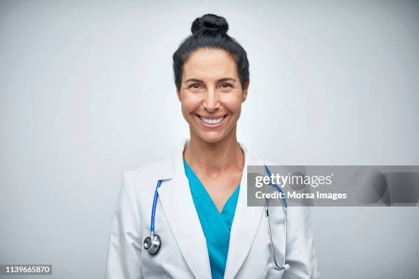 portrait of doctor smiling on white background - arzt portrait stock-fotos und bilder